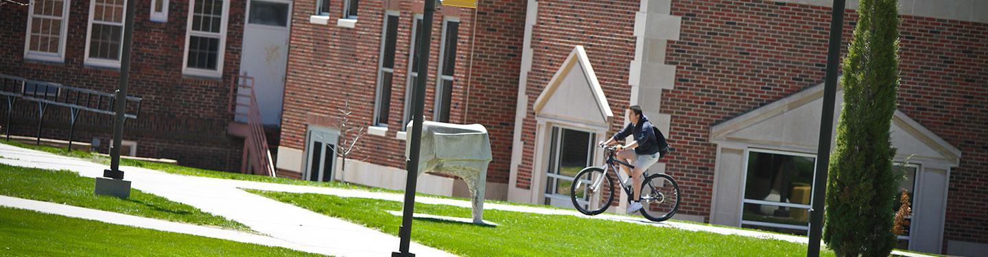 Student on Bike in front of West Center